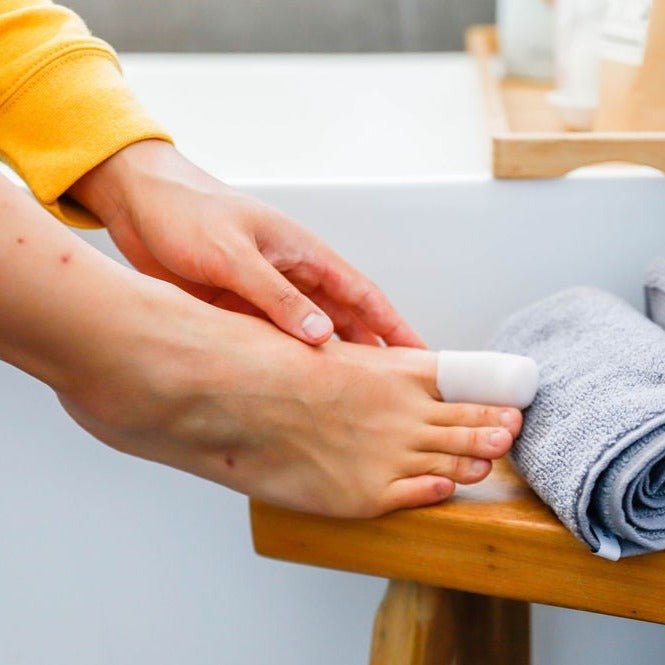 a man with foot on stool with big toe wearing synxgeli large toe sleeve, ideal for treating, reducing or preventing corns, blisters and toe deformities